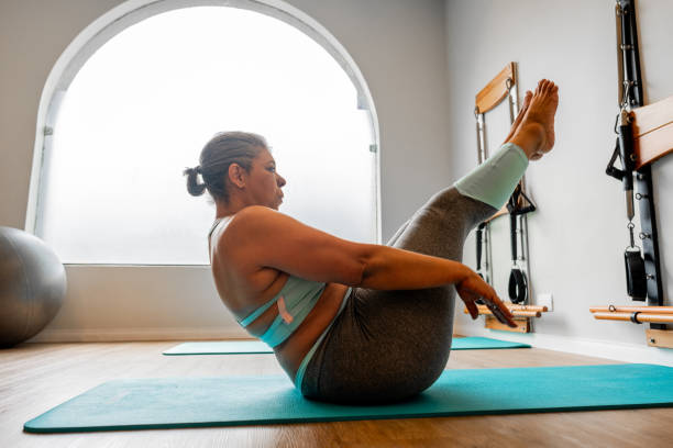 Mature woman exercising at a pilates studio