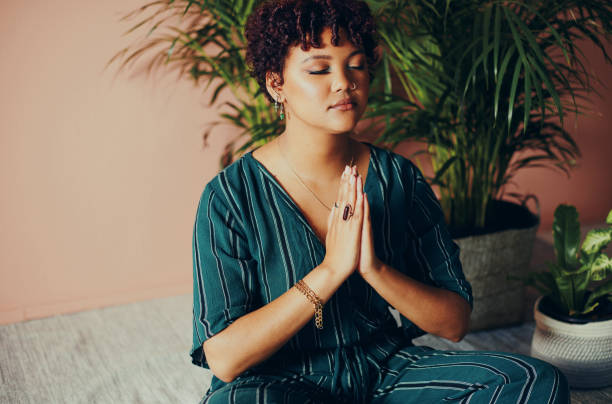 Shot of a beautiful young woman practising yoga at home