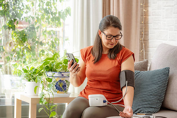 Mature woman using phone to talk with her Doctor about her blood pressure