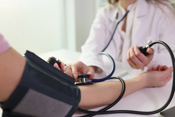 Professionnel de santé mesurant la pression artérielle d'un patient lors d'une consultation