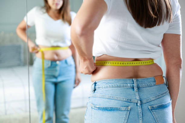Mesure du tour de taille avec un mètre ruban pour surveiller la graisse abdominale après 40 ans