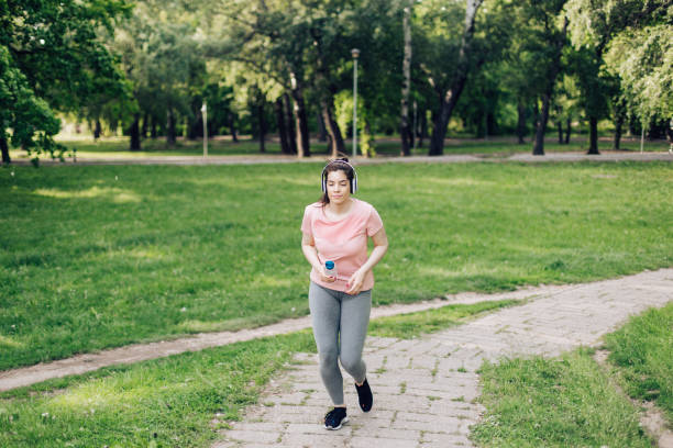 Beautiful girl with headphones jogging outdoors.